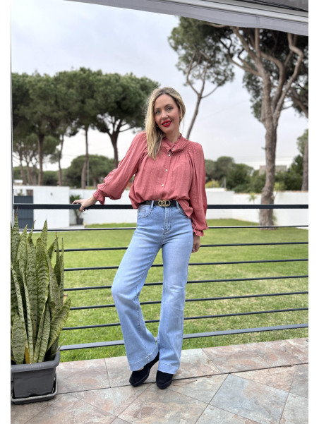 Blusa con plumeti e hilos de brillo color coral.