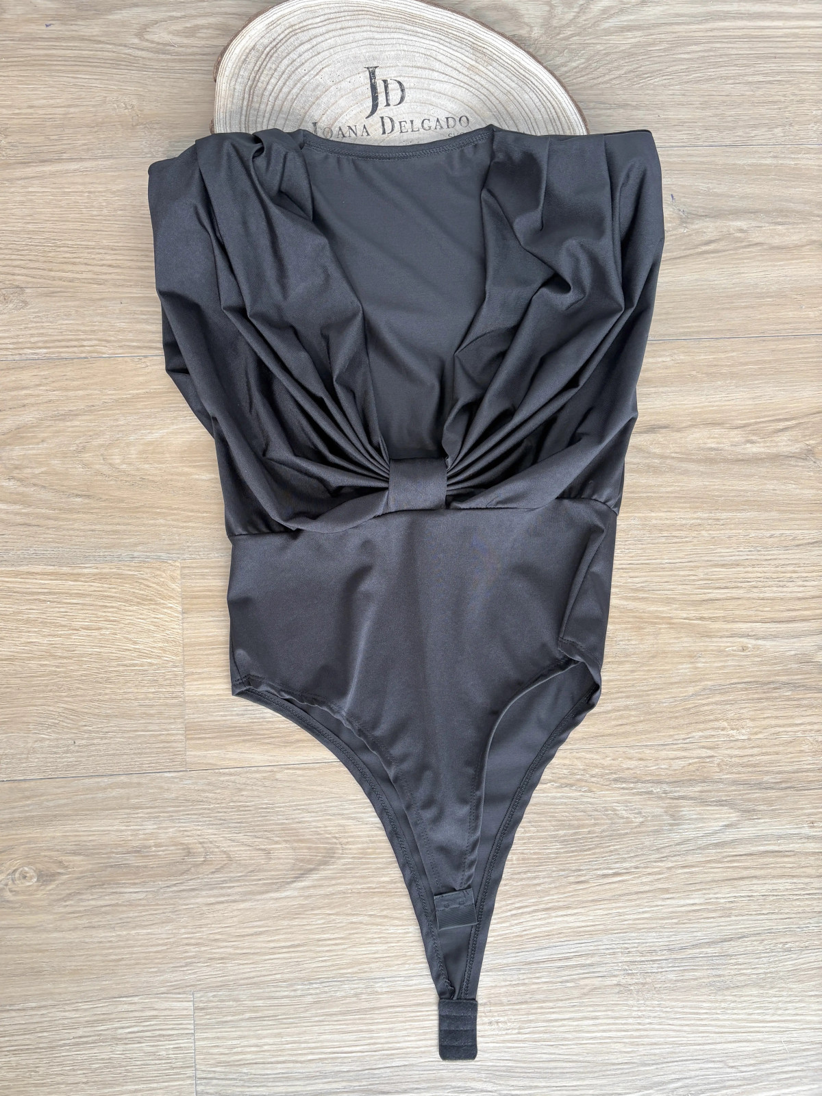 Body negro de tejido elástico escote profundo con hombreras.