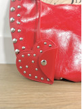 Bolso en tejido de polipiel en color rojo con adorno de tachuelas