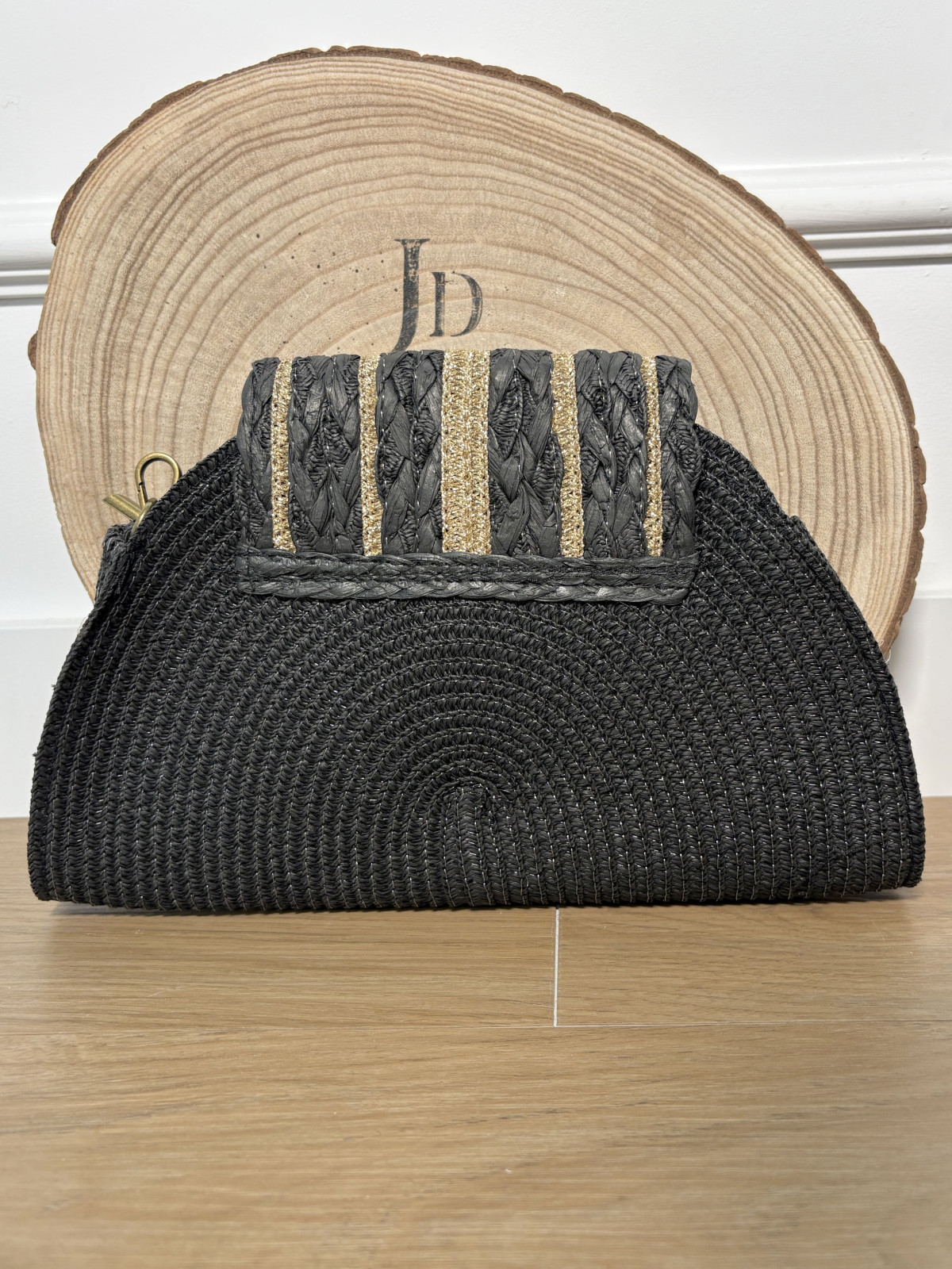 Bolso estilo medialuna de rafia con filos dorados.