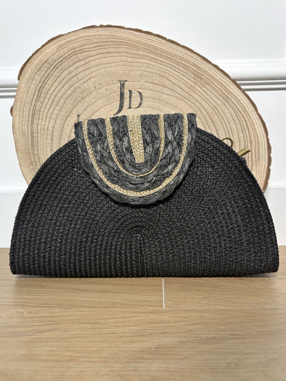 Bolso estilo medialuna de rafia con filos dorados.