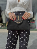 Bolso estilo medialuna de rafia con filos dorados.