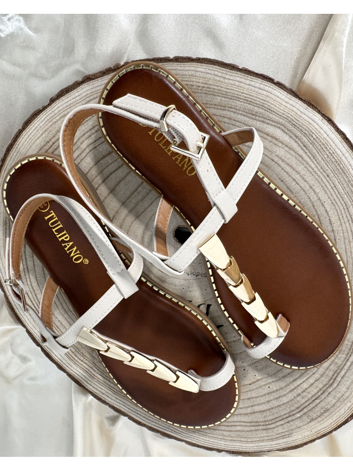 Sandalia de tiras beige, con adorno de chapas metálicas color dorado.