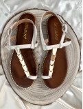Sandalia de tiras beige, con adorno de chapas metálicas color dorado. Sandalia de tiras beige, con adorno de chapas metálicas color dorado.
