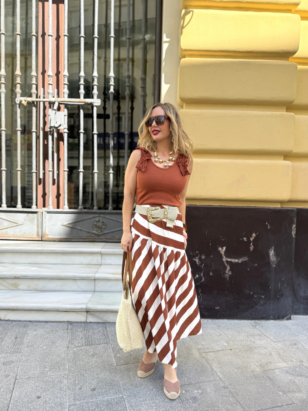 Falda midi de vuelo con estampado de rayas beige y marrón.