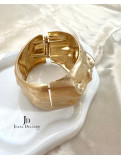 Brazalete metálico dorado con relieve.
