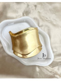 Brazalete metálico dorado con diseño ondulado, ideal para complementar